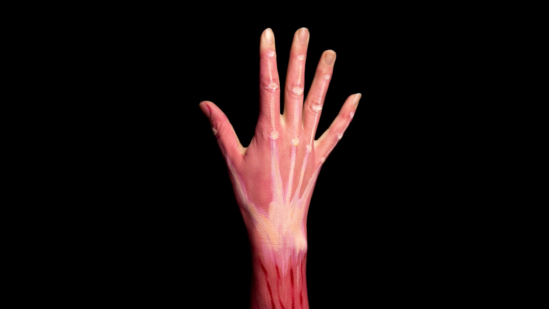 persons left hand with pink paint