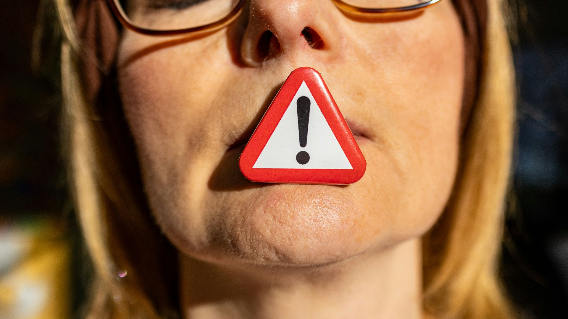 A woman with a red and white warning sign on her nose