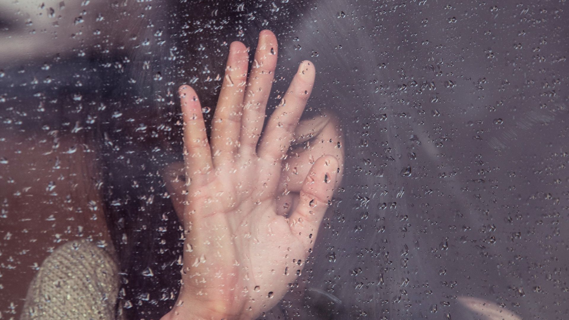 woman touch rainy glass