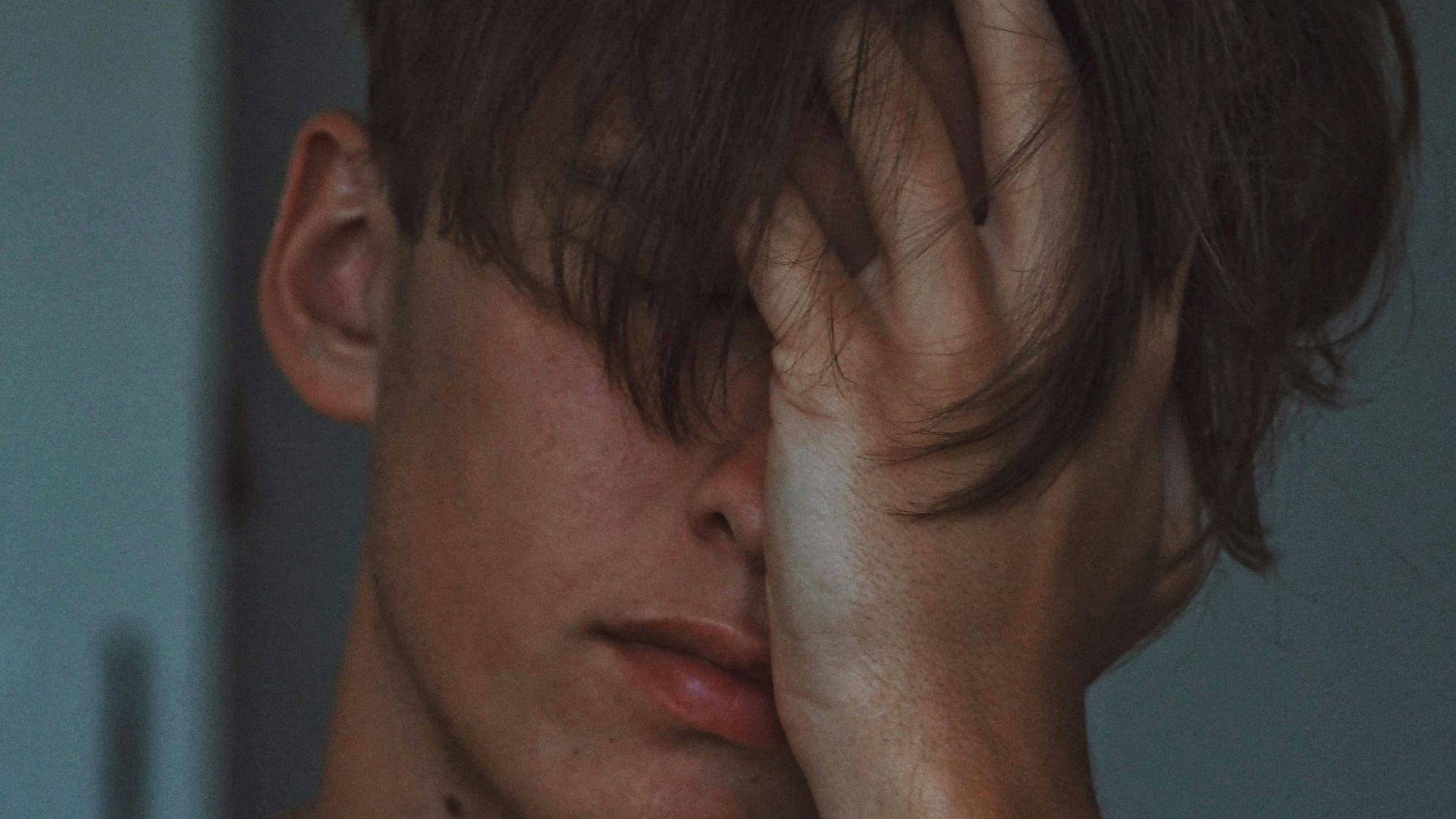 man covering face using right hand