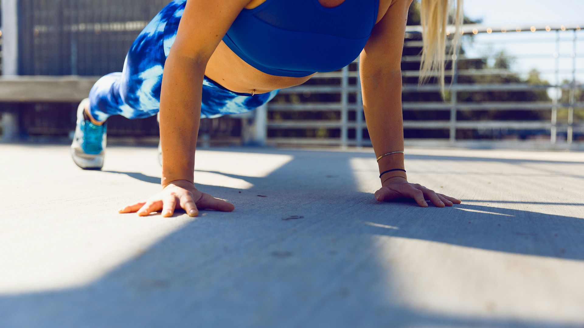woman planking on gray asphalt road