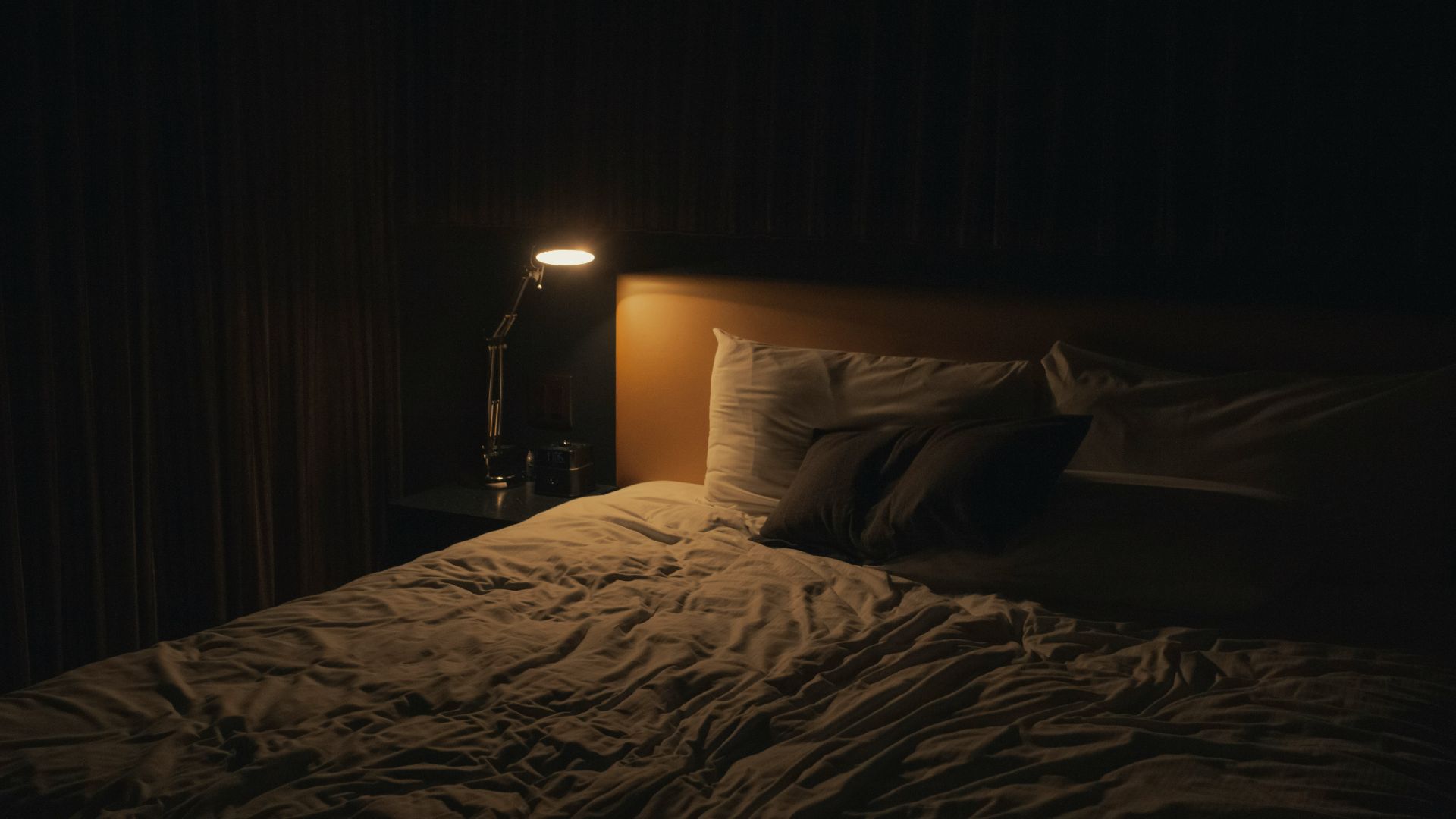 table lamp turned-on near bed