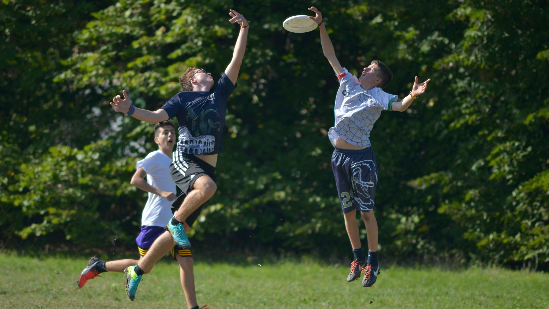 2 women playing soccer on green grass field during daytime
