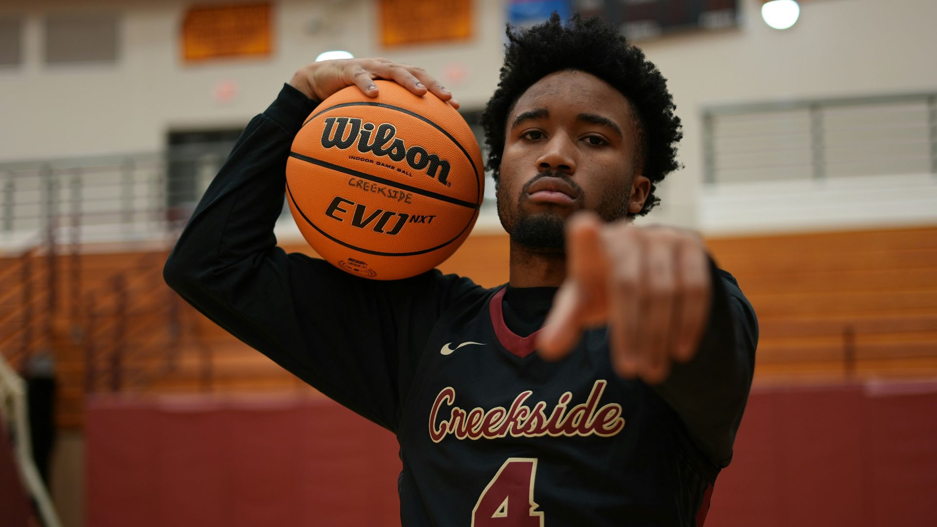 a man holding a basketball in a gym