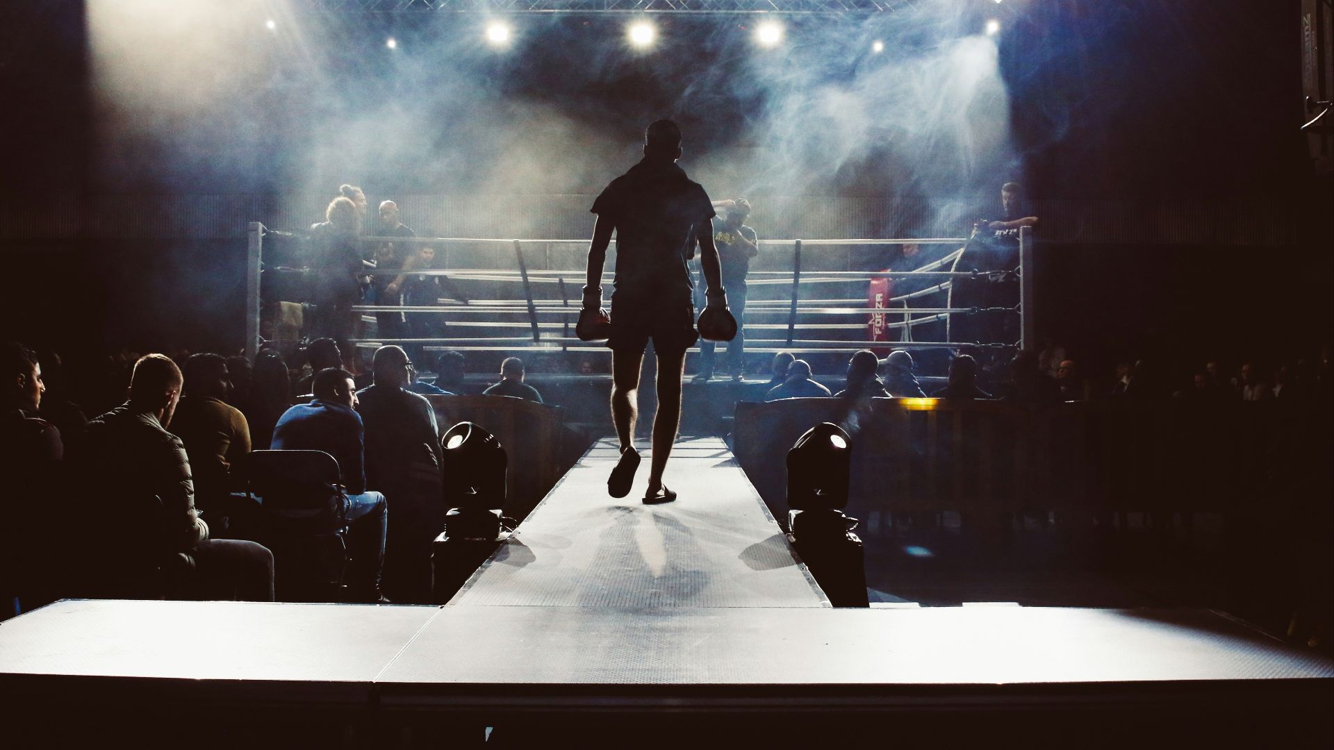 man standing and walking going on boxing ring surrounded with people