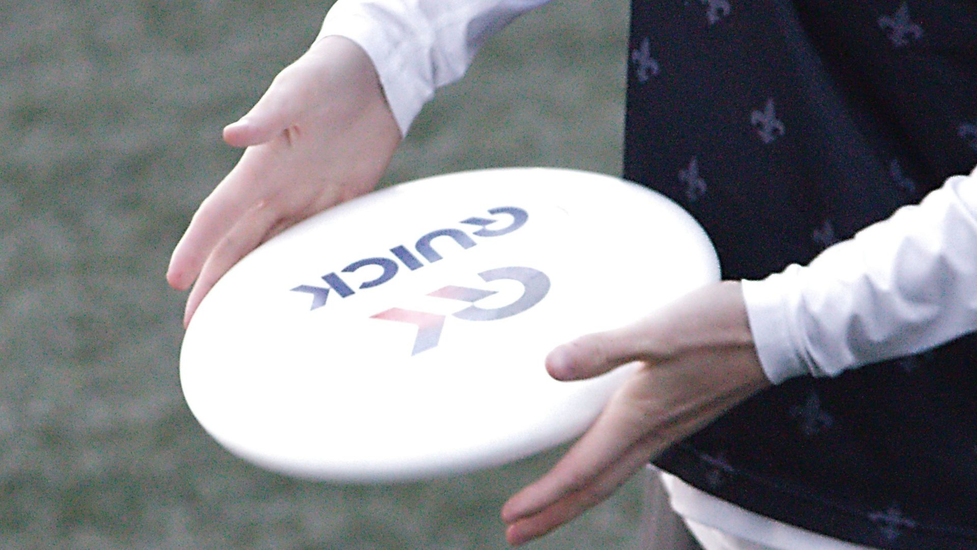 a man holding a white frisbee on top of a field