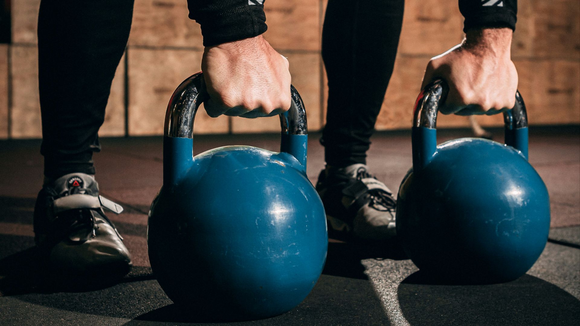 a pair of hands holding two blue kettles