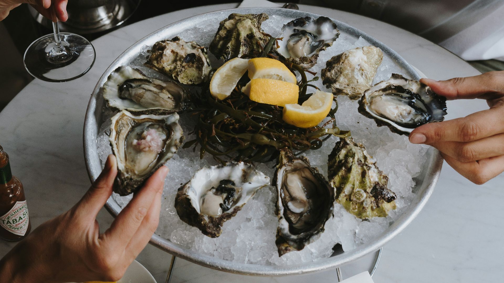 a table topped with oysters and wine glasses