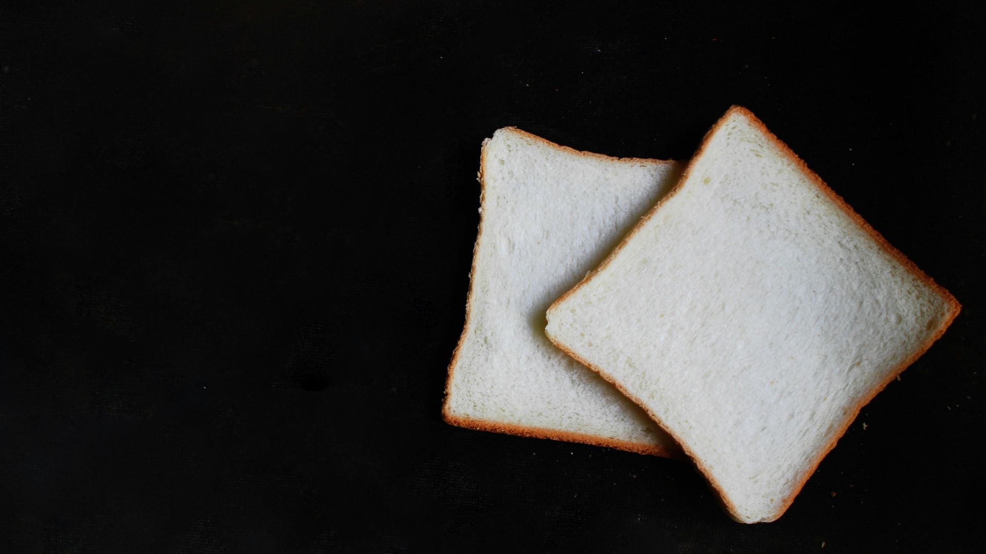 two slices of breads on top of black surface