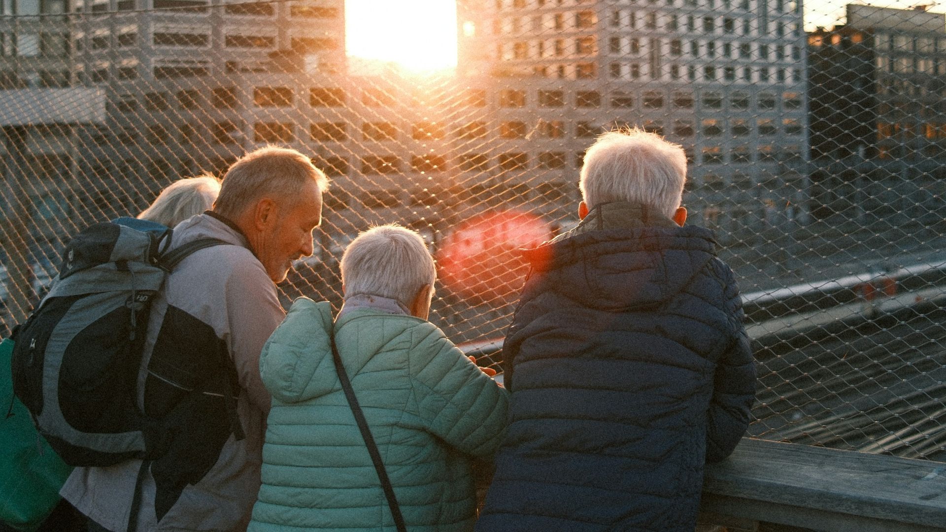 People watching sunset over city buildings