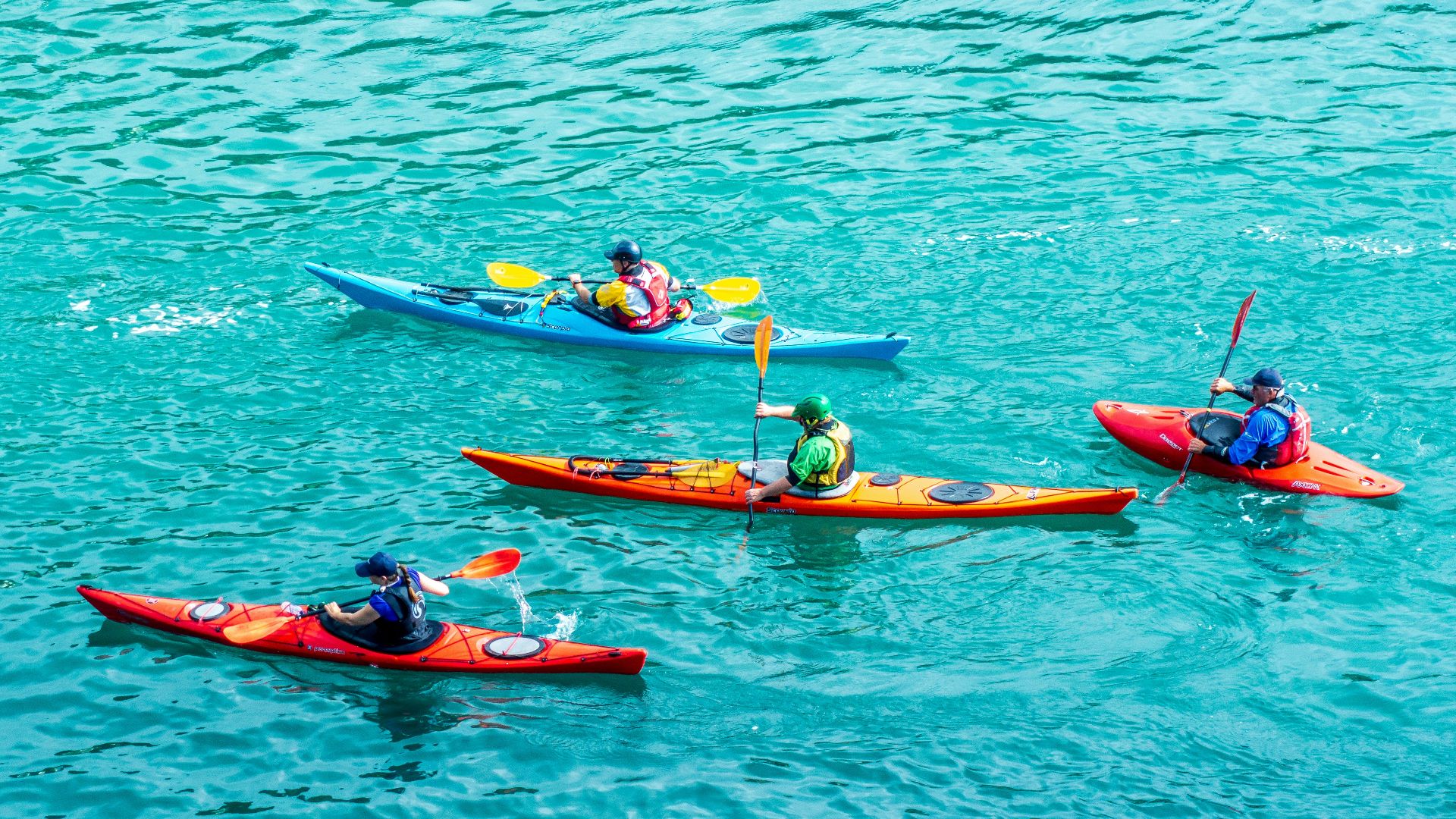 2 person riding on red kayak on body of water during daytime