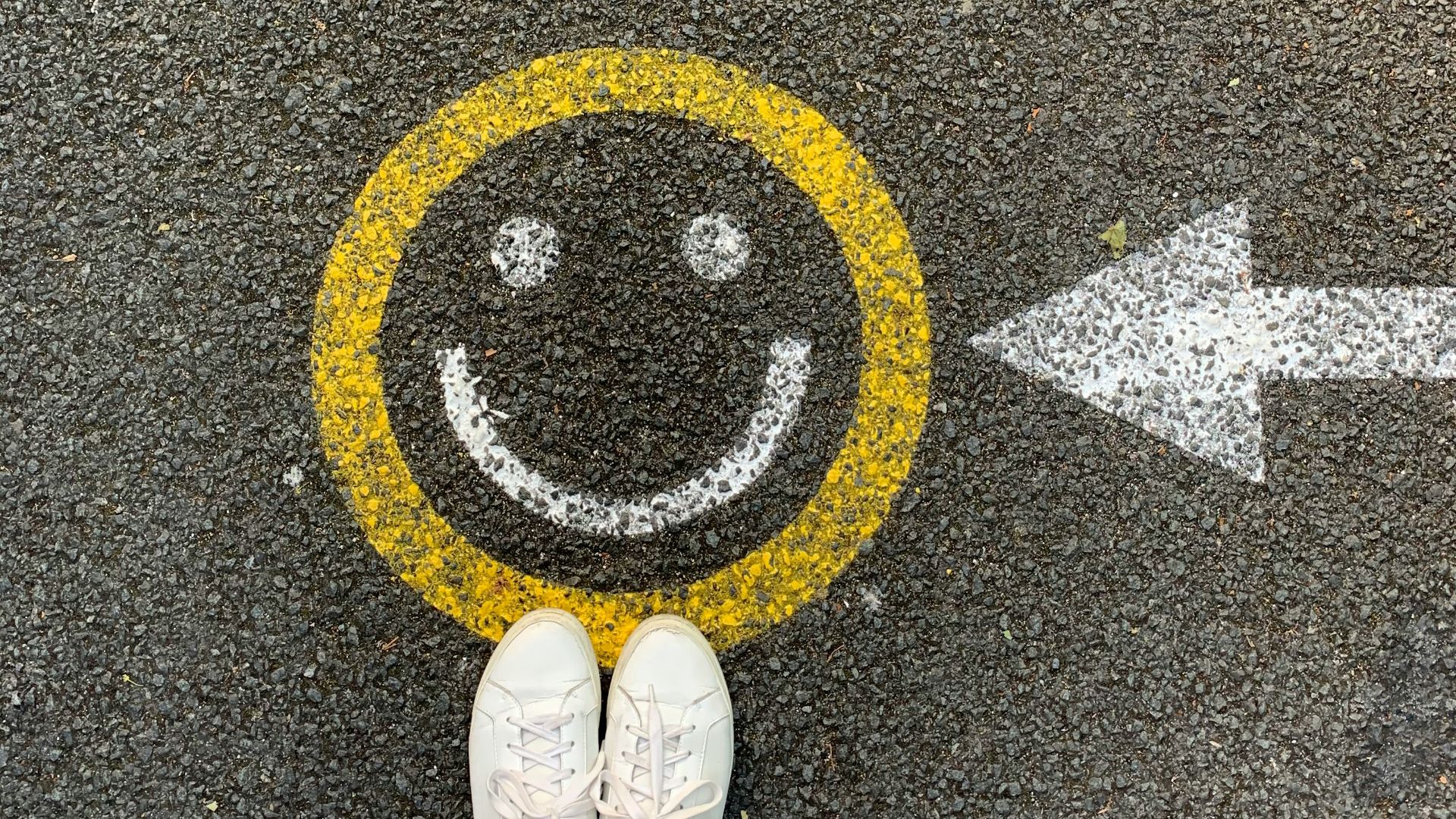 person in white shoes standing on gray concrete road