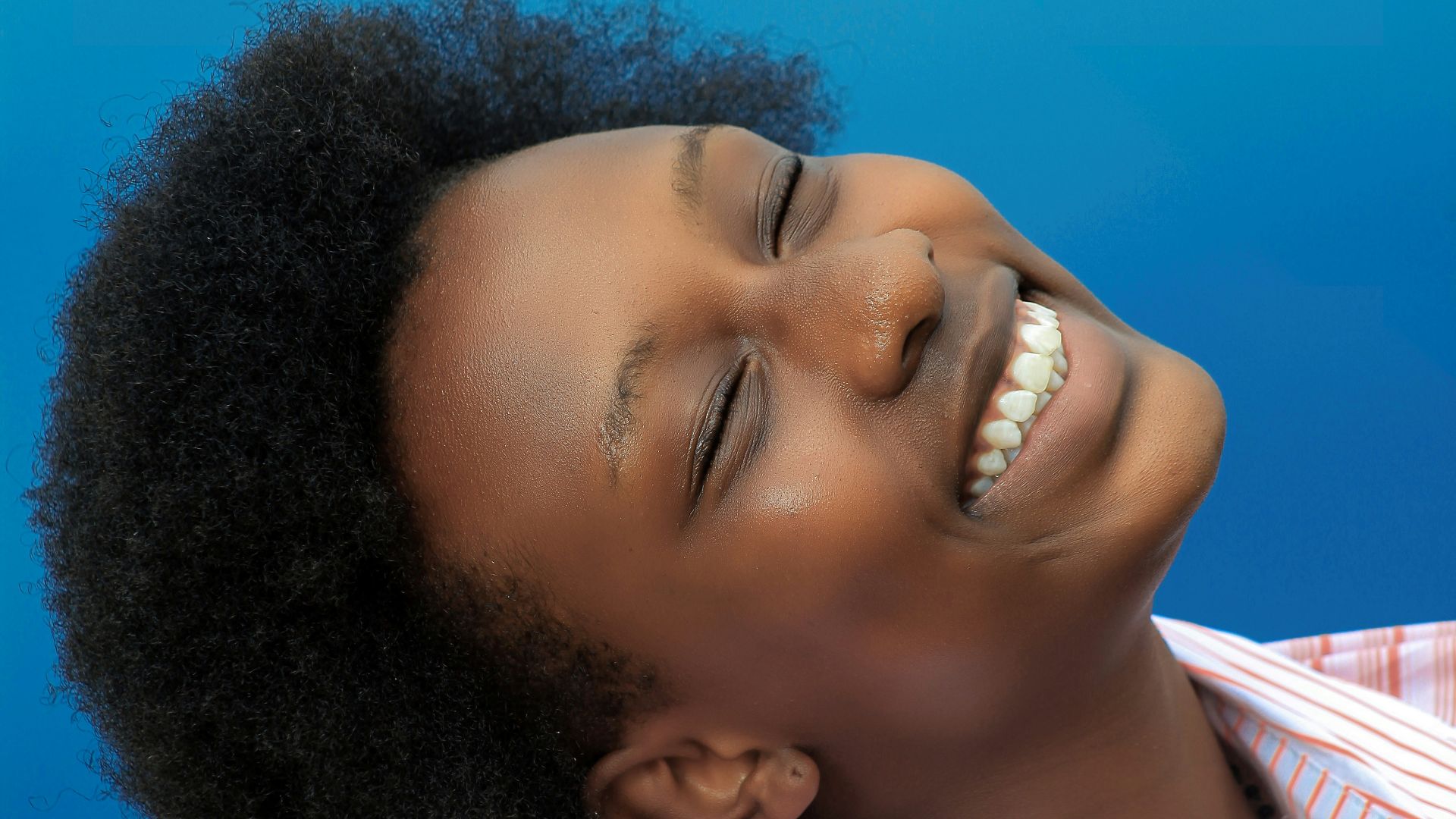 smiling girl in pink and white stripe shirt