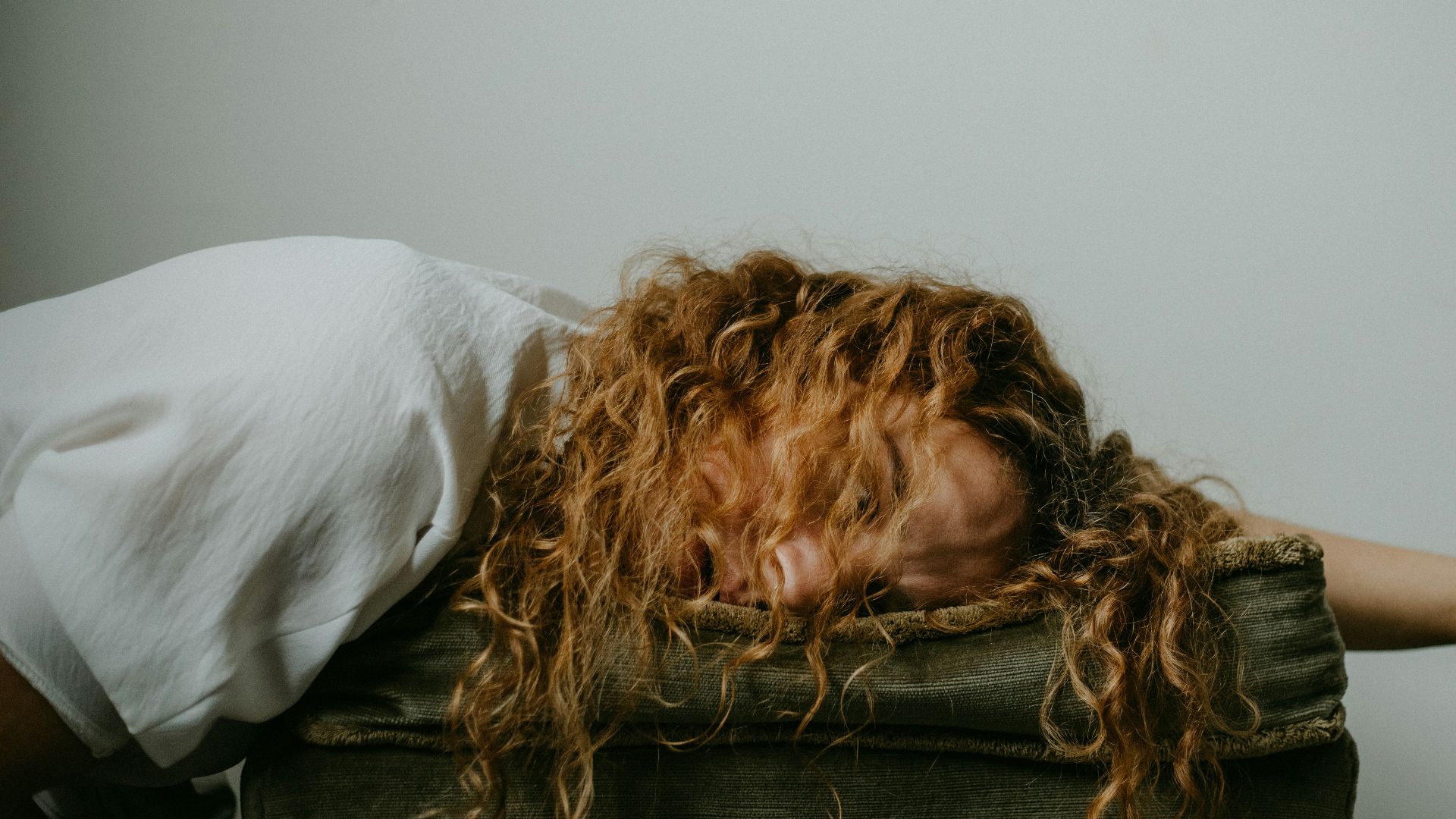 woman in white shirt lying on black textile