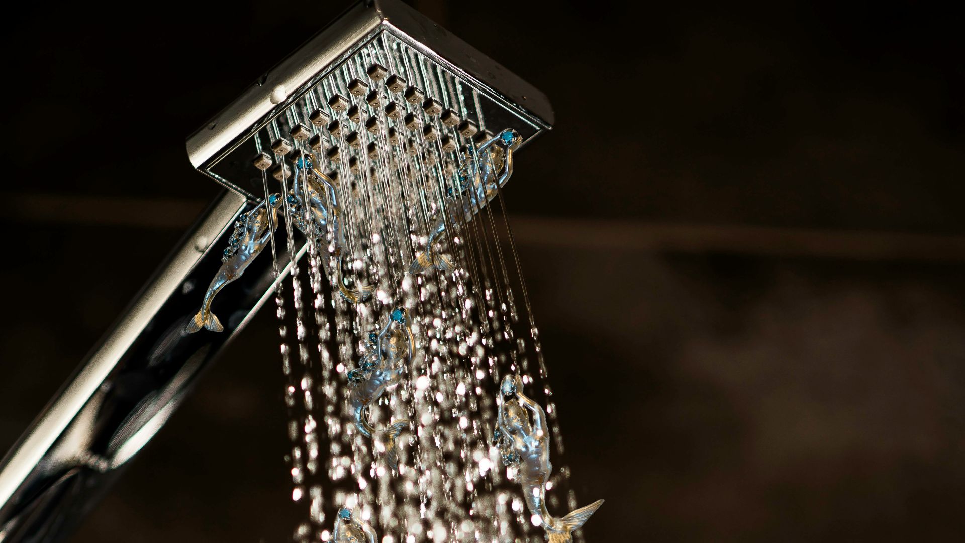 a close up of a shower head with water coming out of it