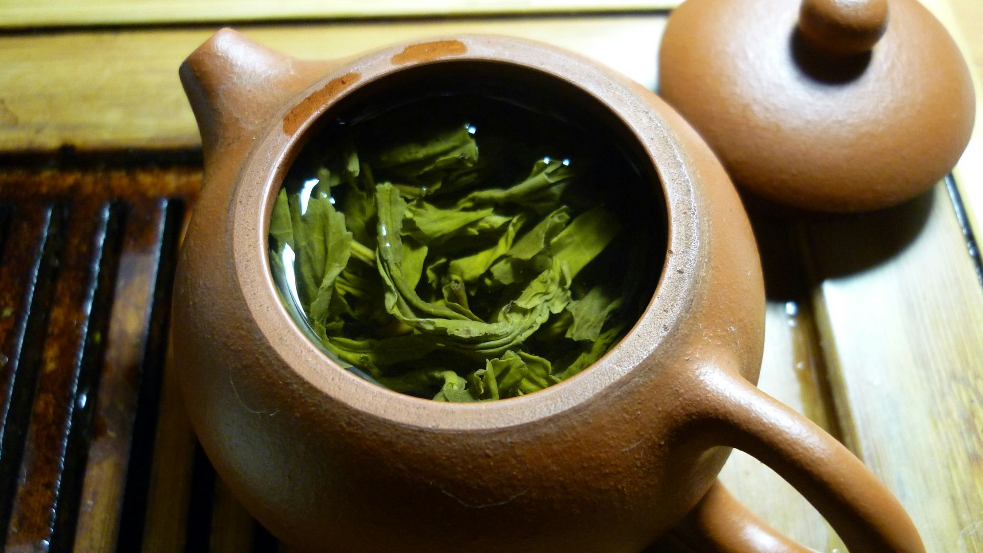 green leaves and clear liquid inside teapot