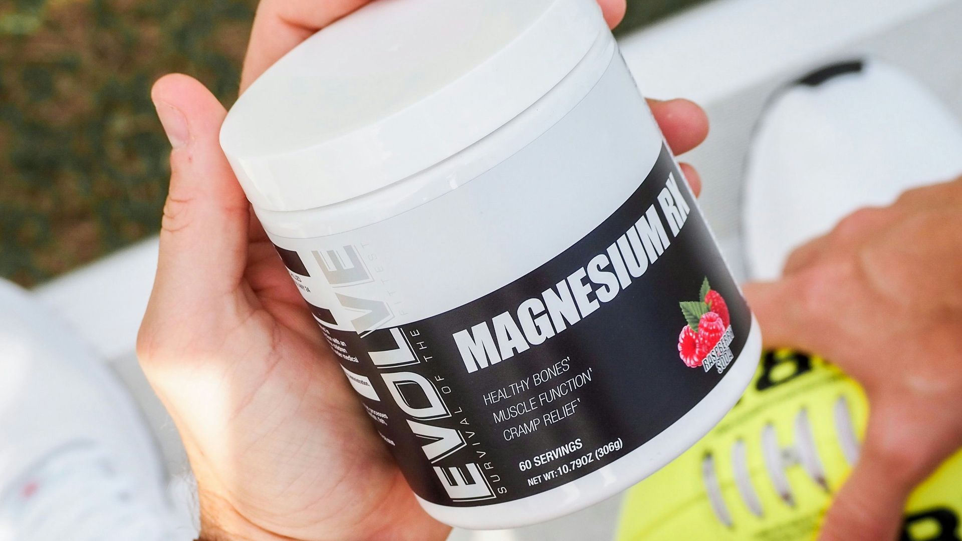 a man holding a jar of vitamin supplement