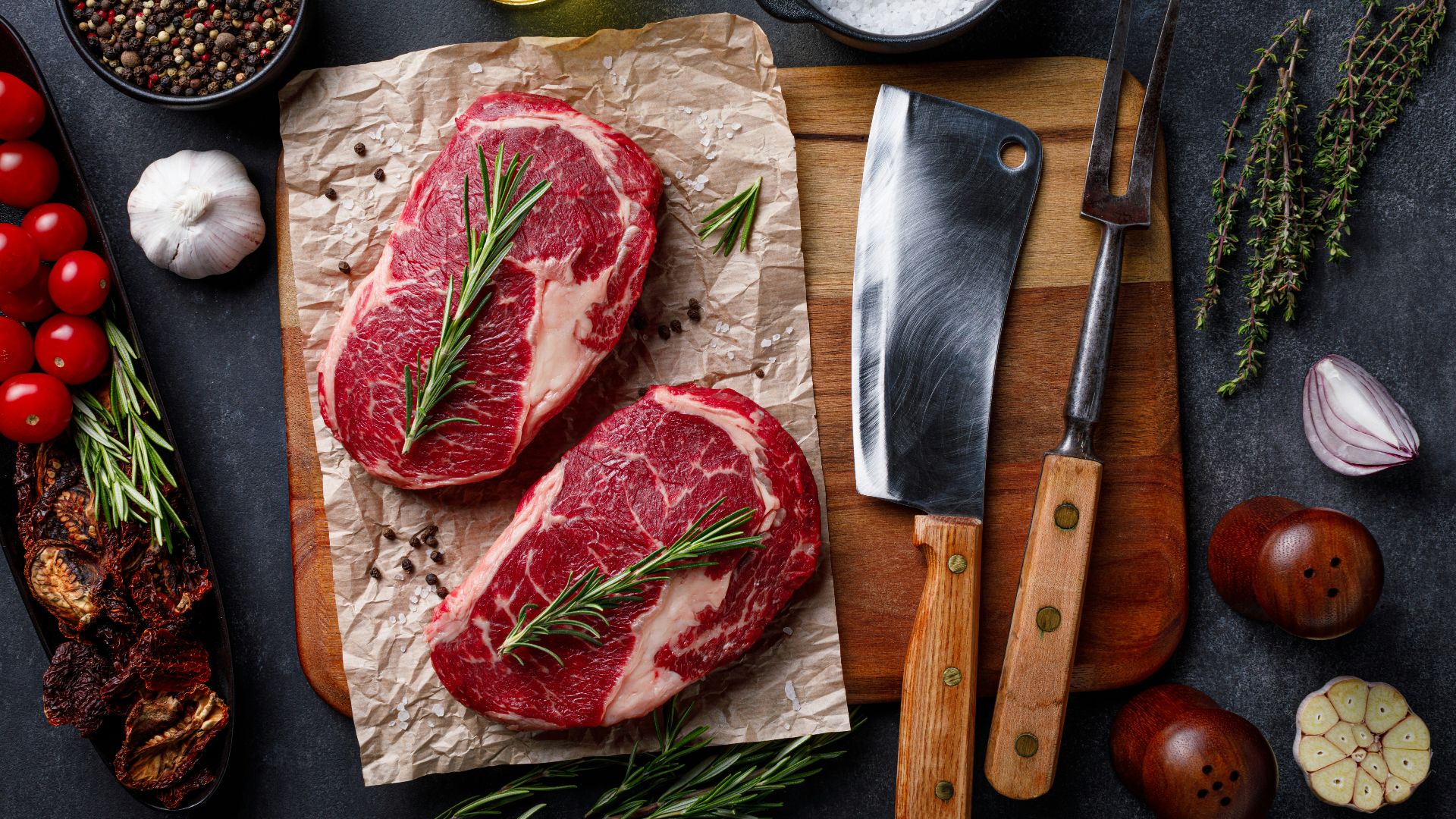 a cutting board topped with raw meat next to a knife