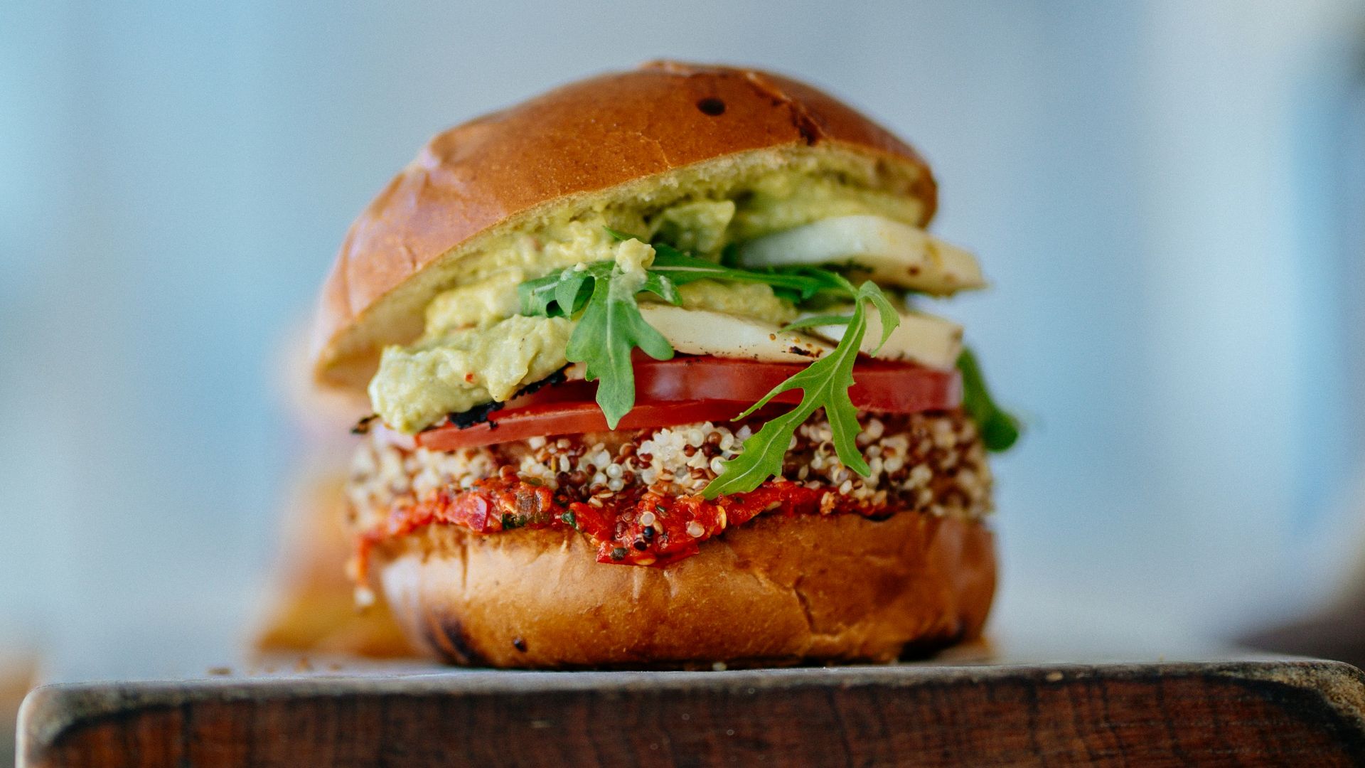 selective focus photography of hamburger with sliced tomatoes and vegetables