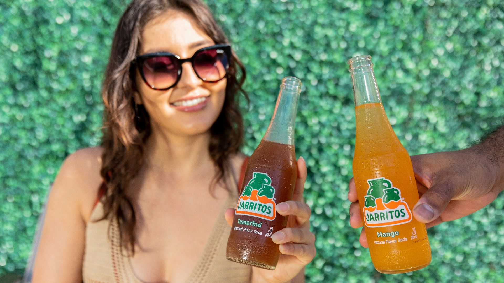 a woman holding two bottles of orange juice