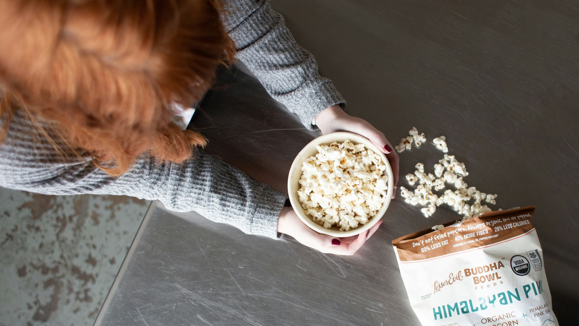 woman holding bowl of popcorn