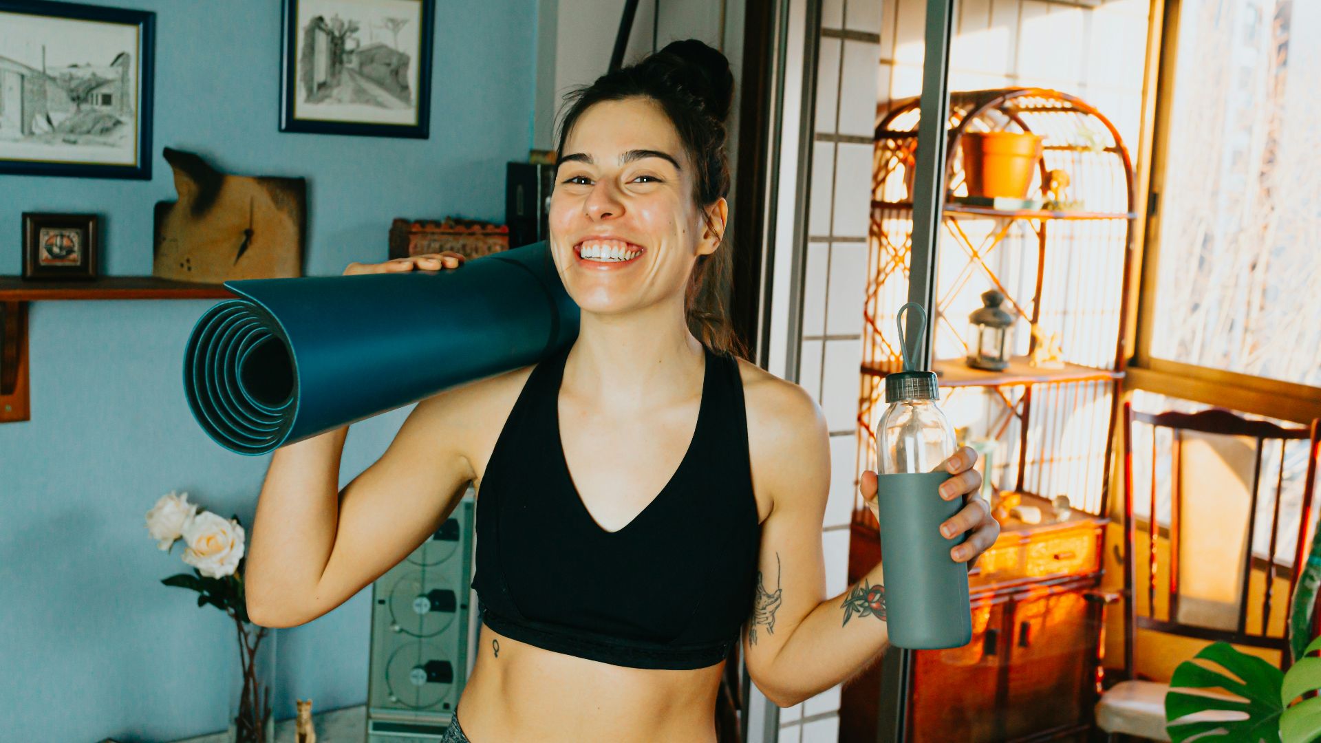 woman in black sports bra holding blue and black kettle