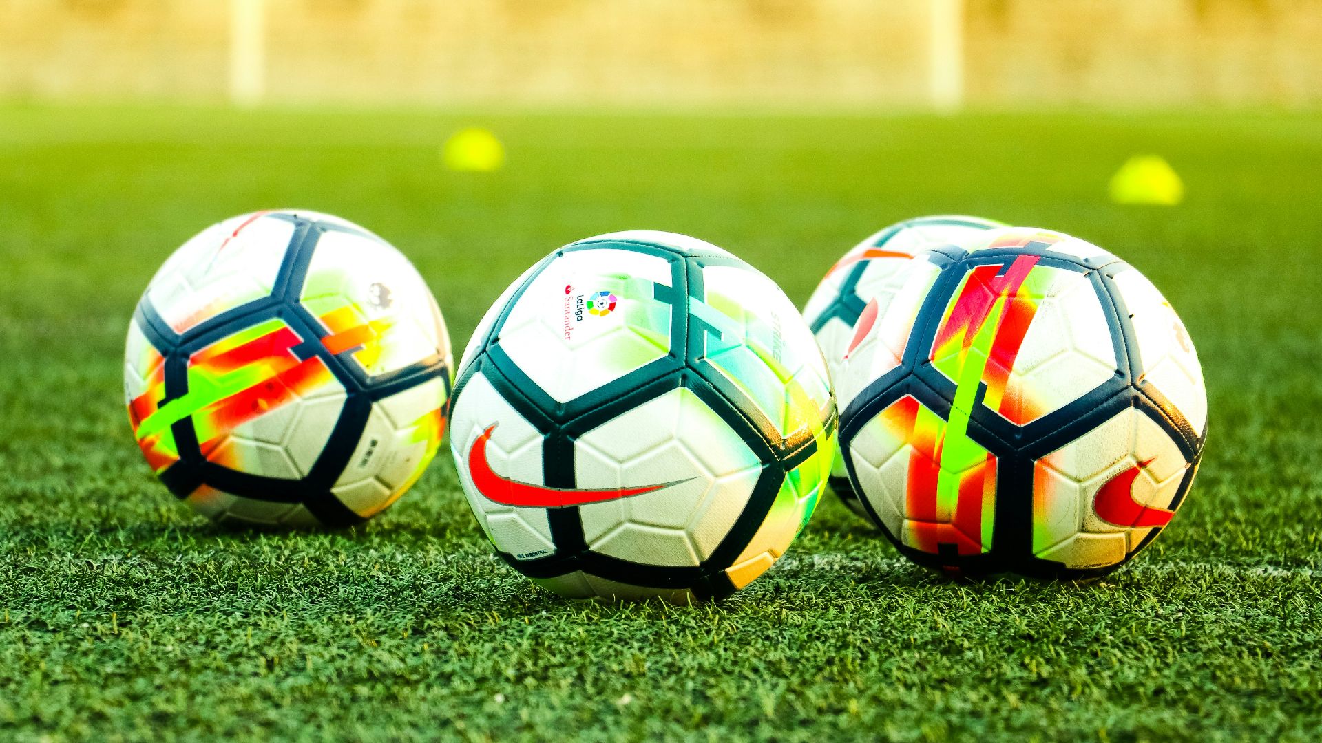 three white-and-black soccer balls on field