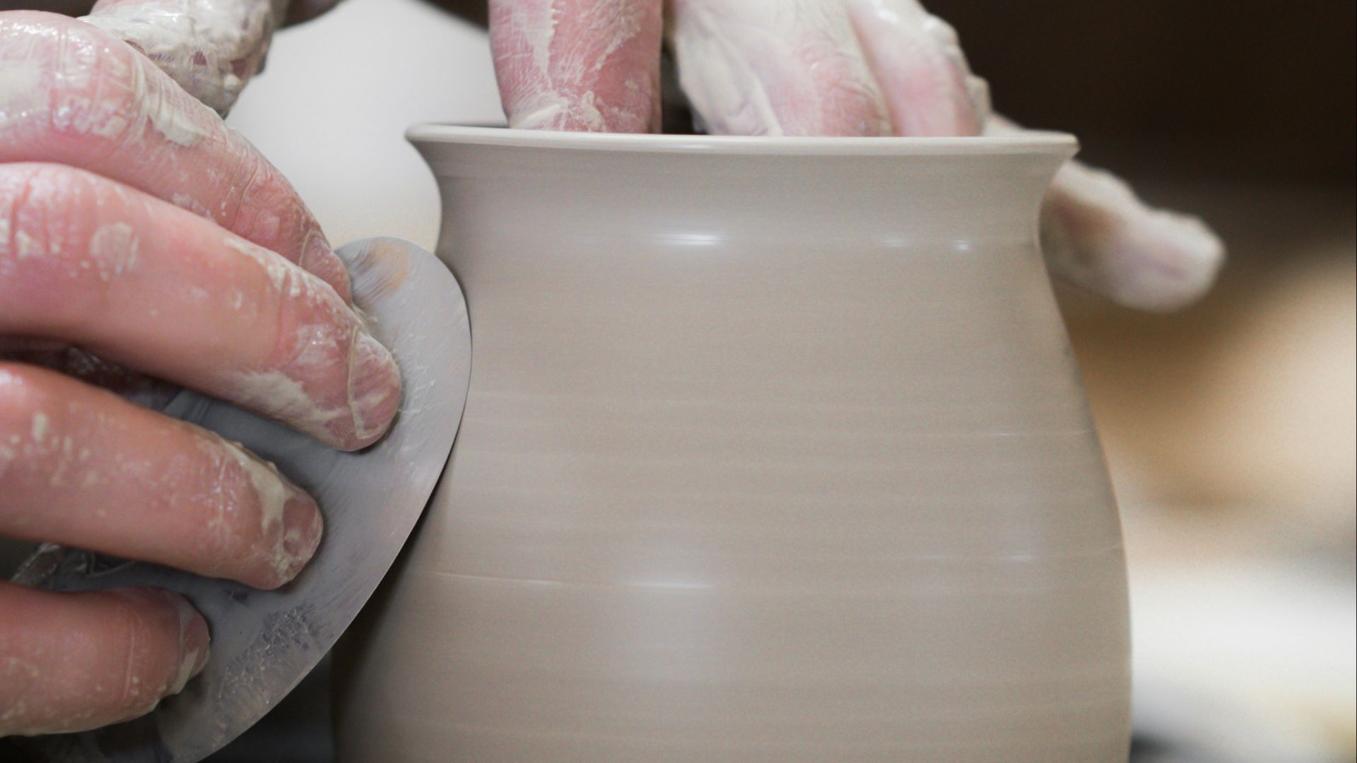 person holding white clay pot