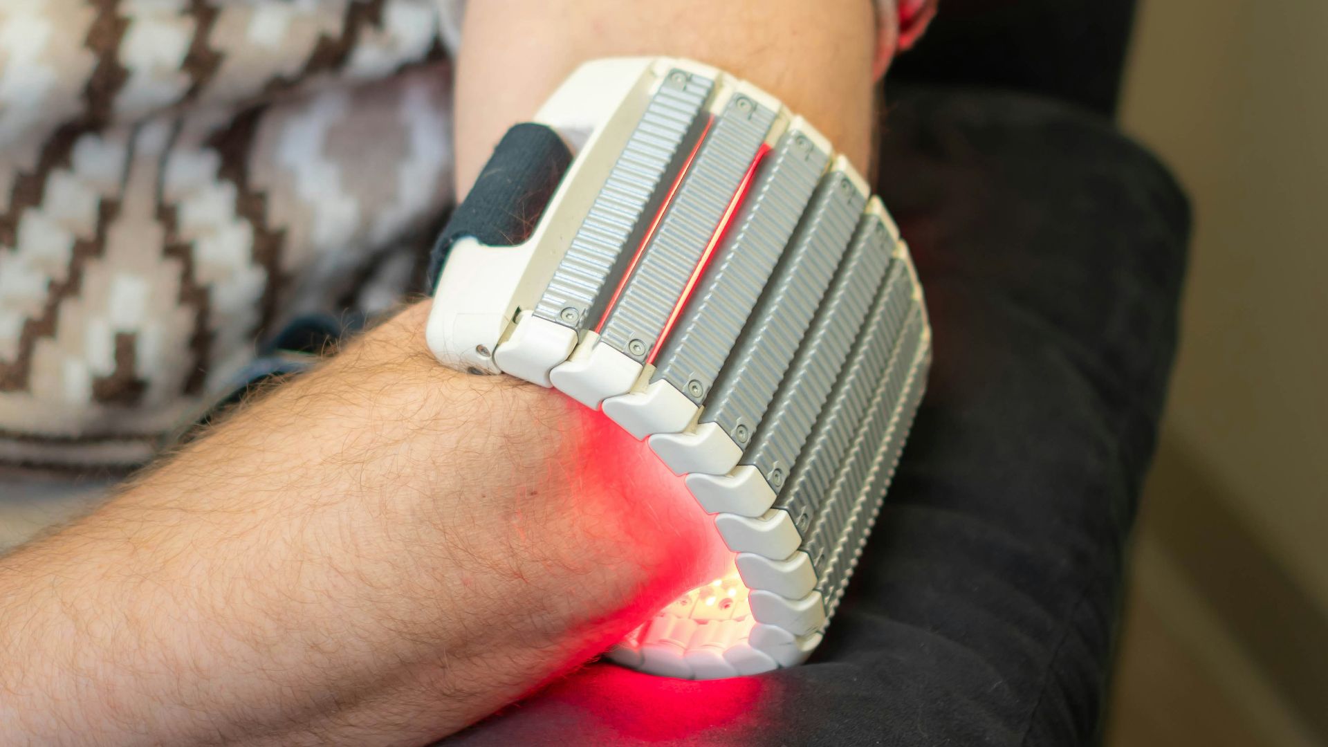 Person with red light therapy device on arm