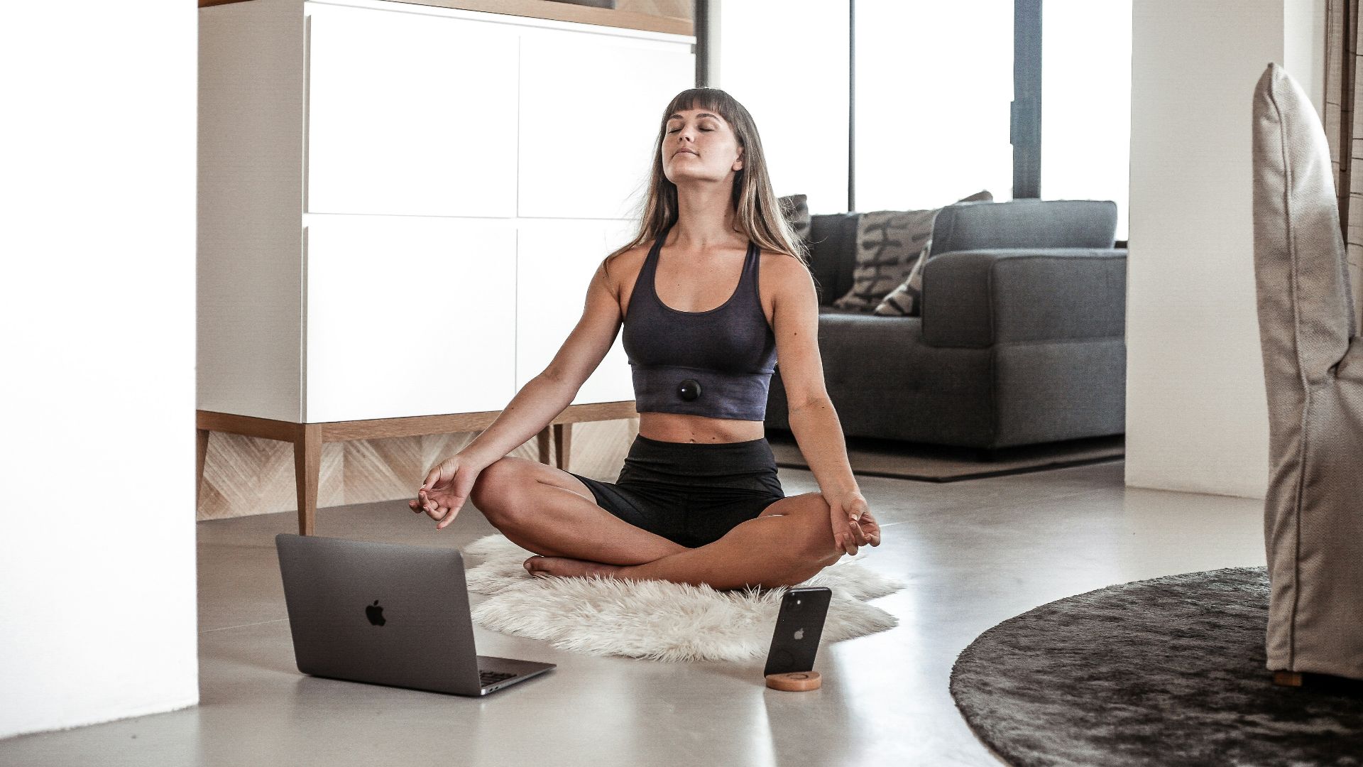 a woman sitting on the floor with a laptop