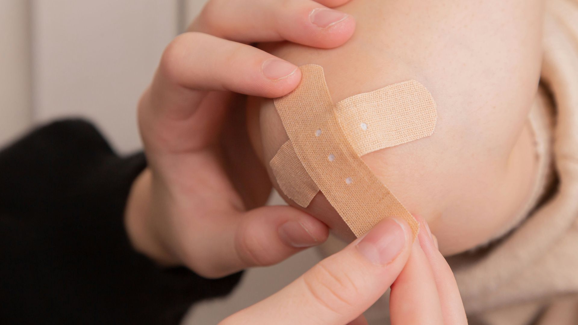 person holding band aid on left hand