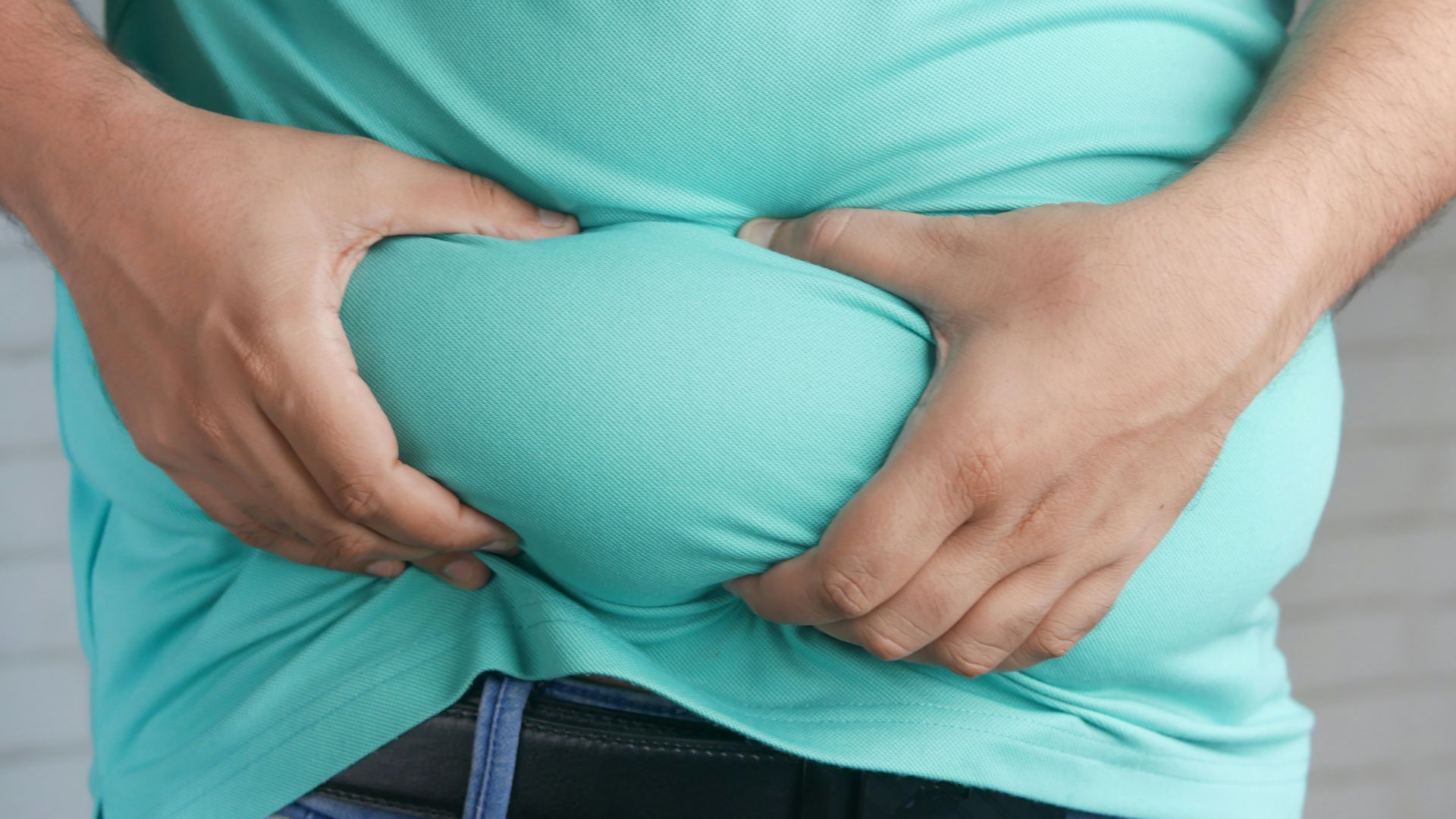 a man holding his stomach with his hands
