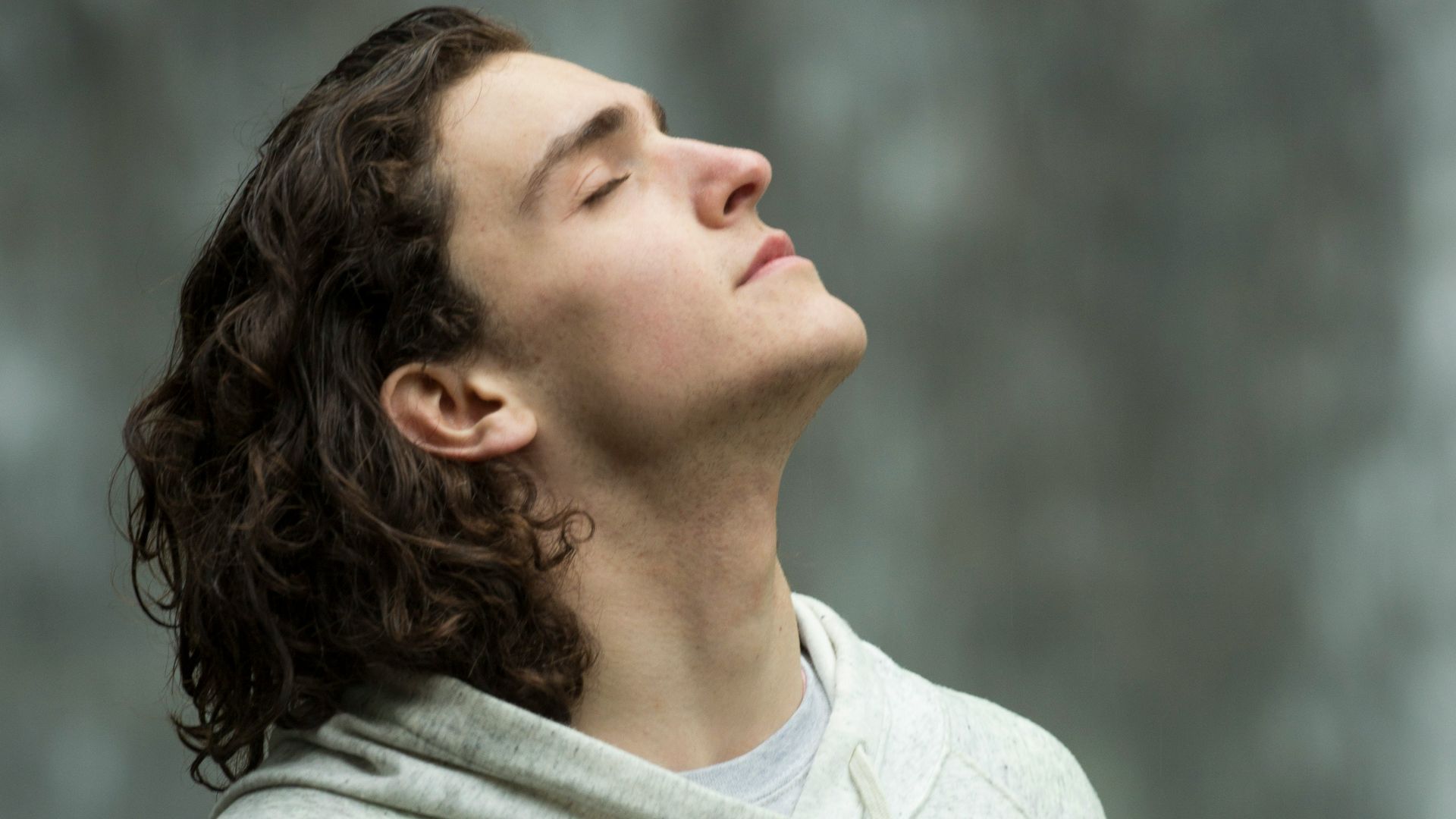 man in gray pullover hoodie closed eyes while heads up