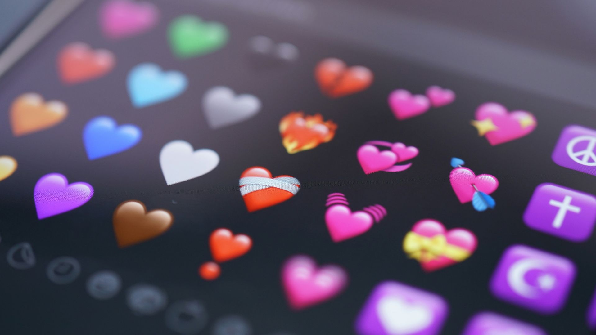 A phone screen displays colorful heart emojis.
