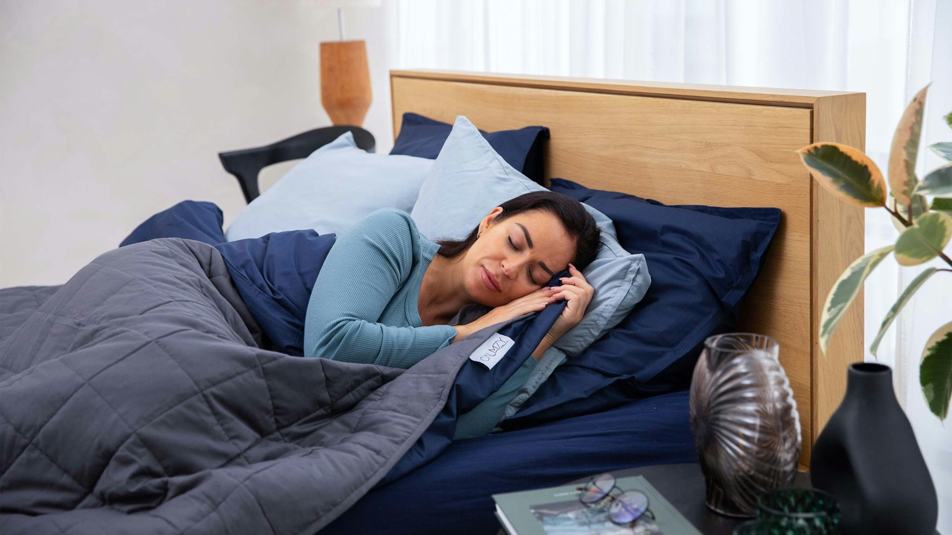a woman laying in bed talking on a cell phone