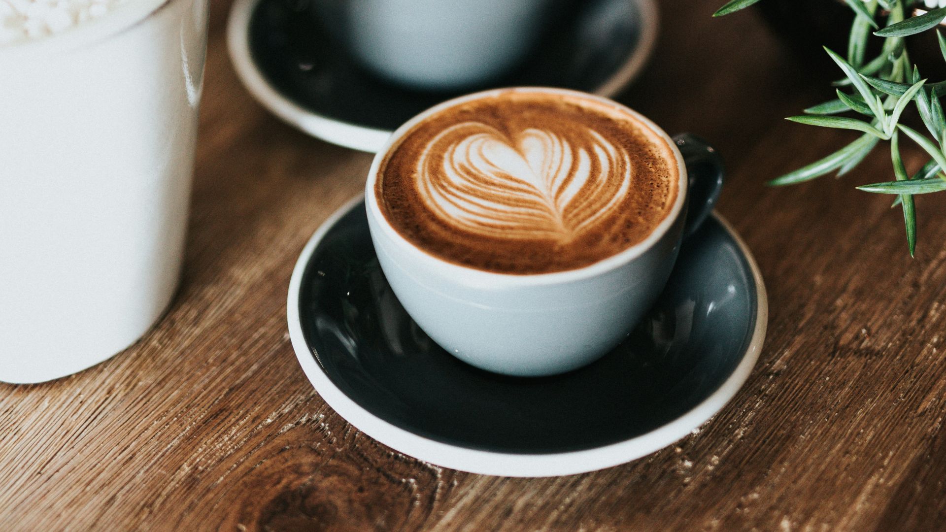shallow focus photography of coffee late in mug on table