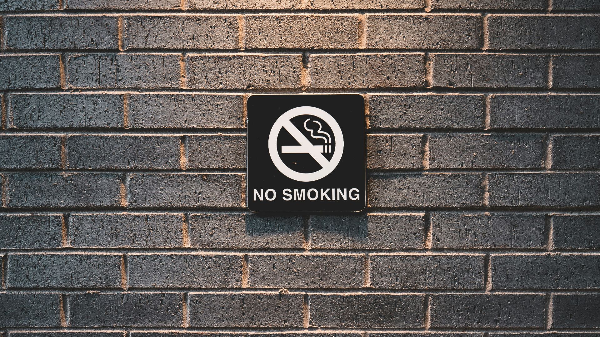 no smoking sign on brick wall