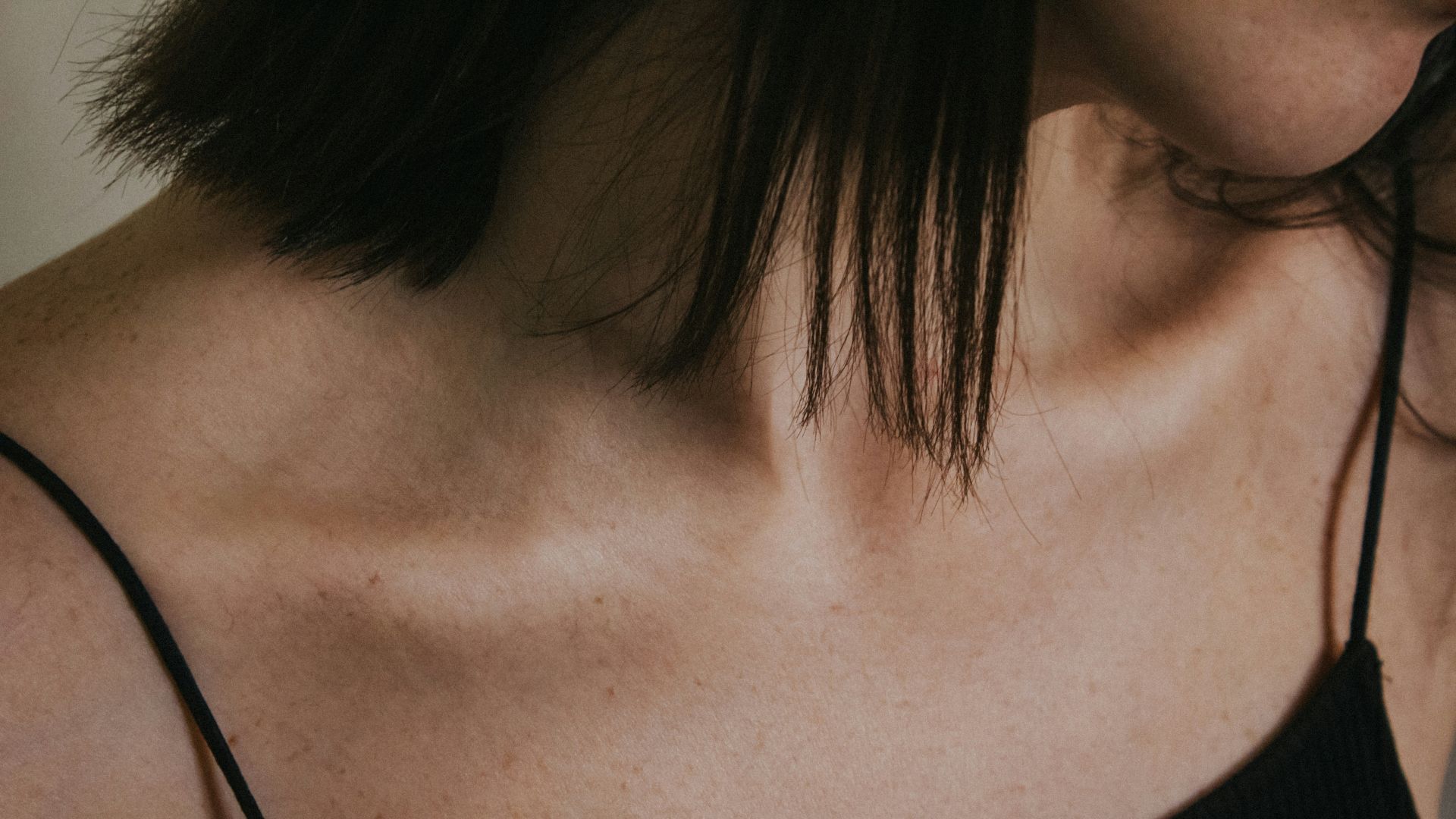 a close up of a woman wearing a black top