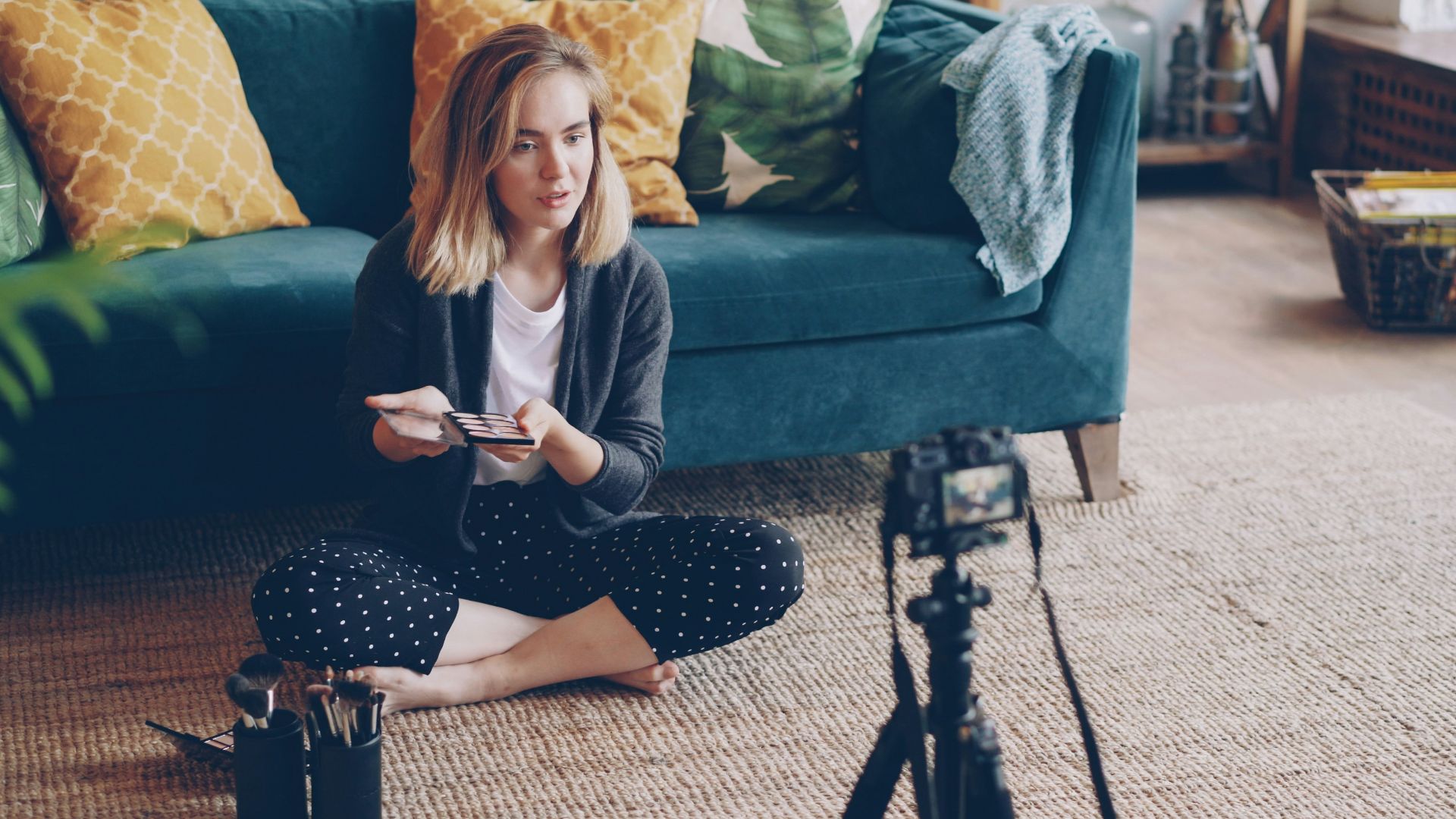 Woman filming herself with a camera in a living room