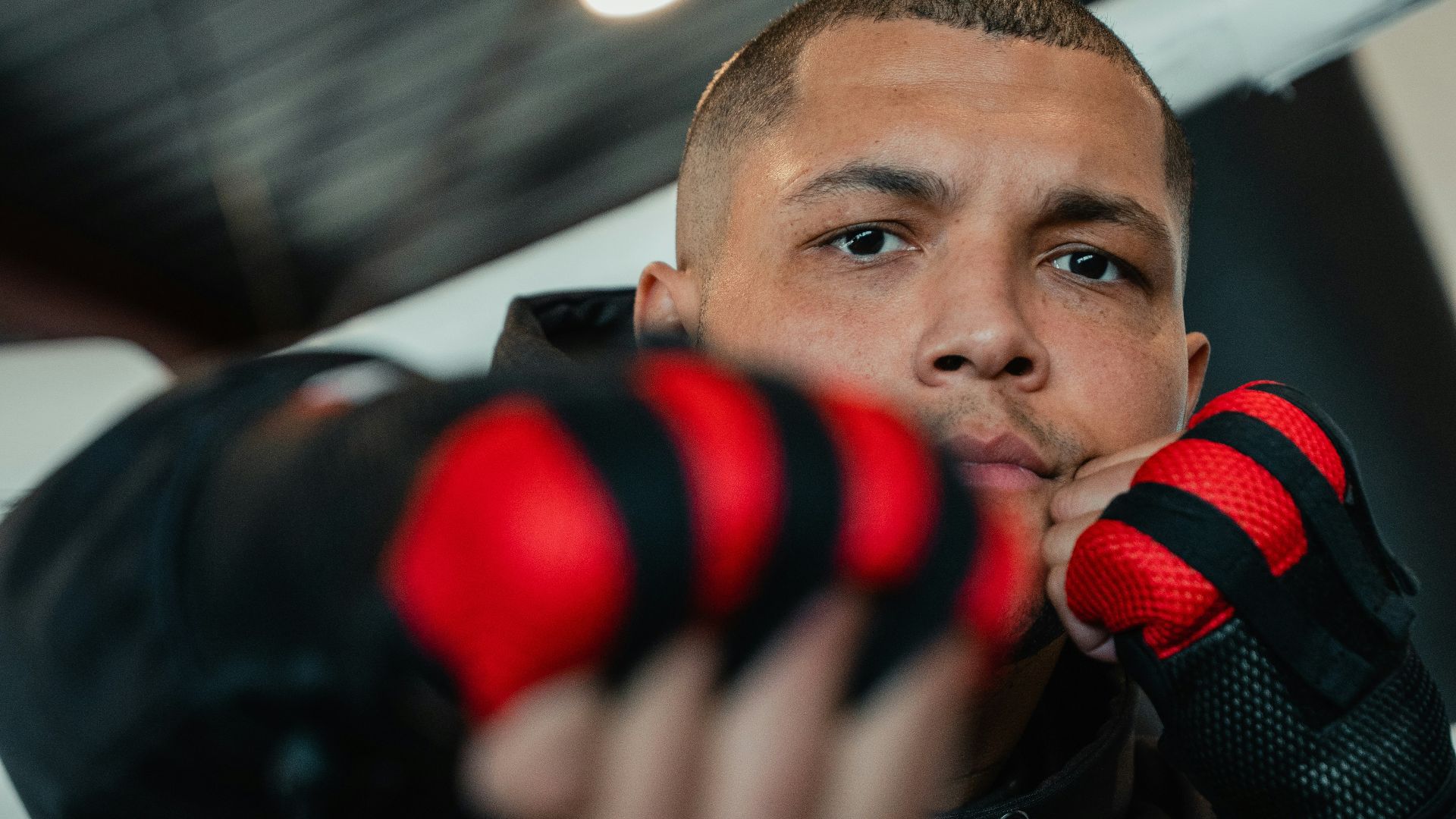 A man in a black leather jacket pointing a finger at the camera