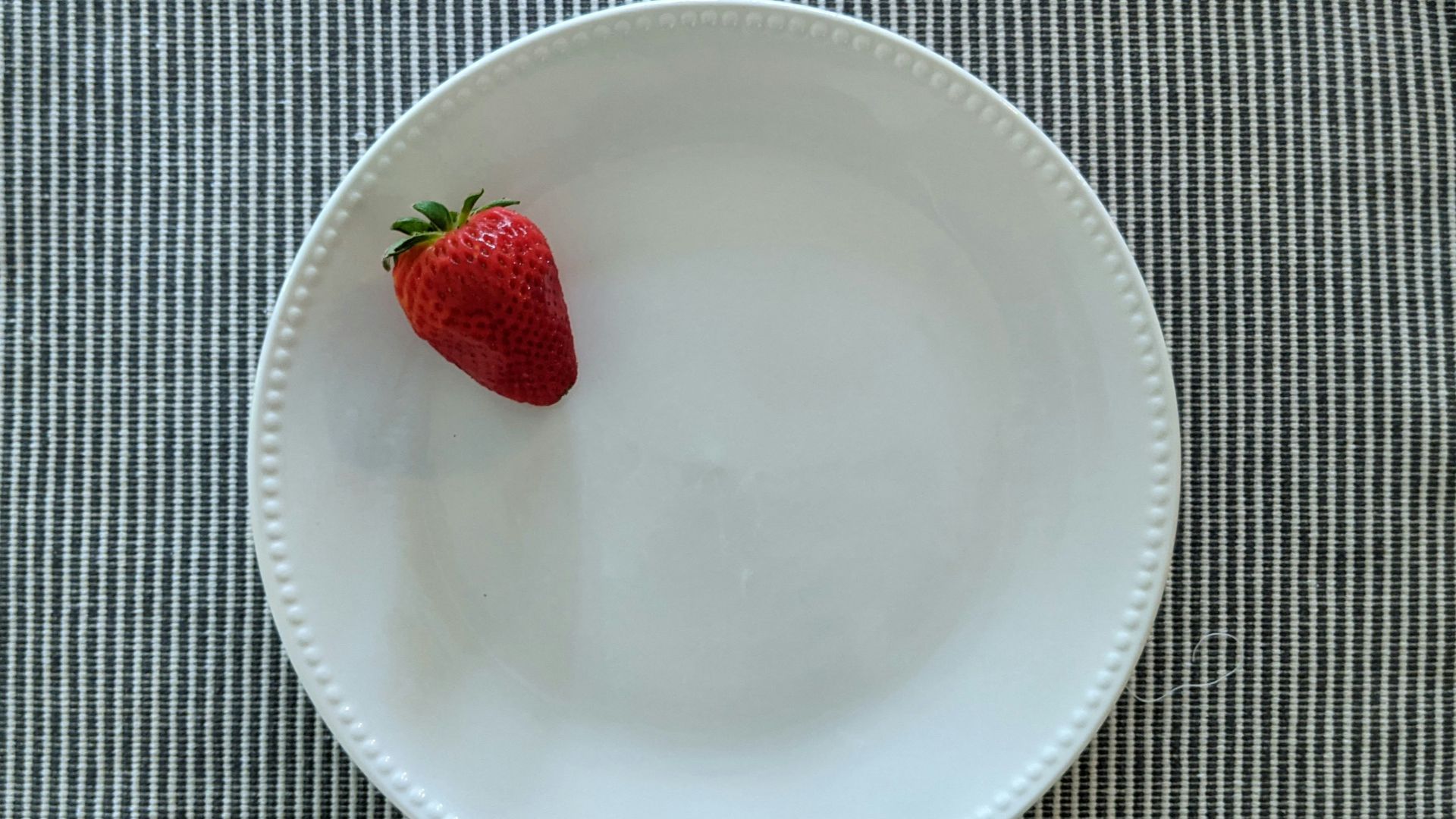 red strawberry on white ceramic plate