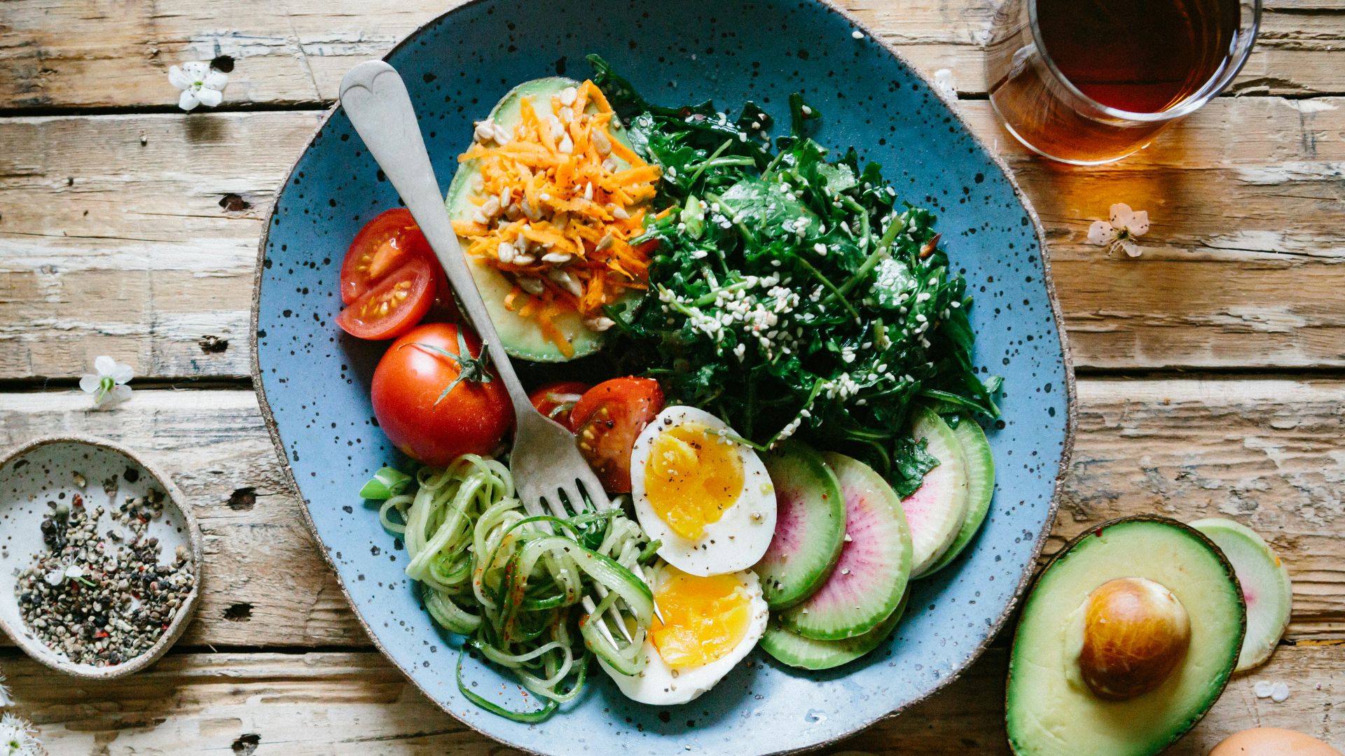 poached egg with vegetables and tomatoes on blue plate