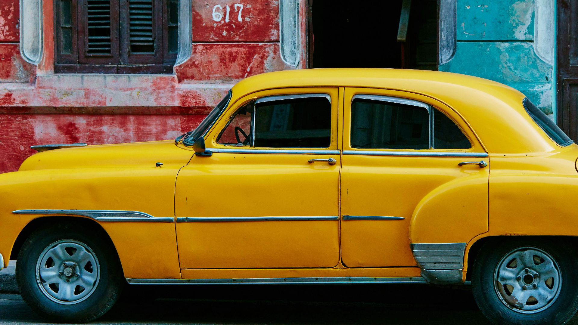 yellow sedan parked near red concrete building