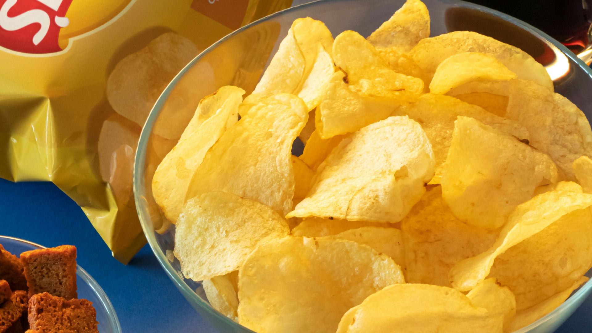 clear drinking glass beside brown bread on blue ceramic plate