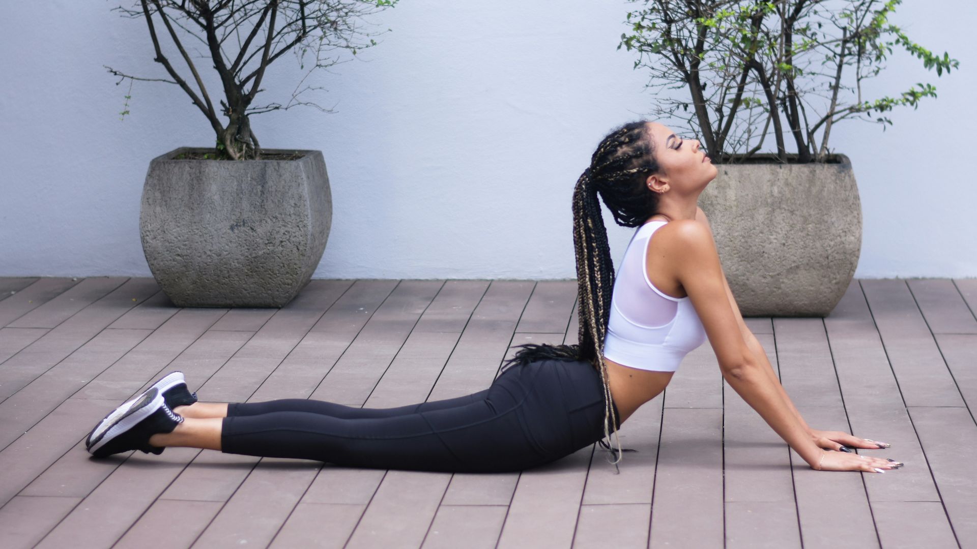 woman in white sports bra and black leggings doing yoga