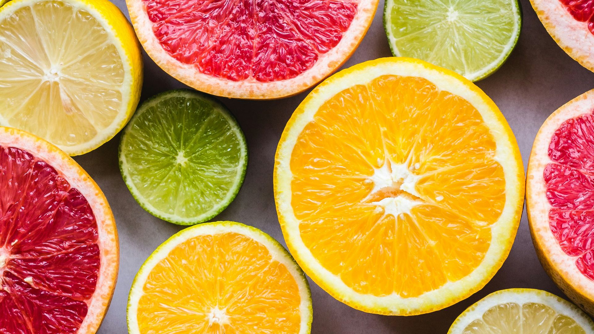 flat lay photography of sliced pomegranate, lime, and lemon