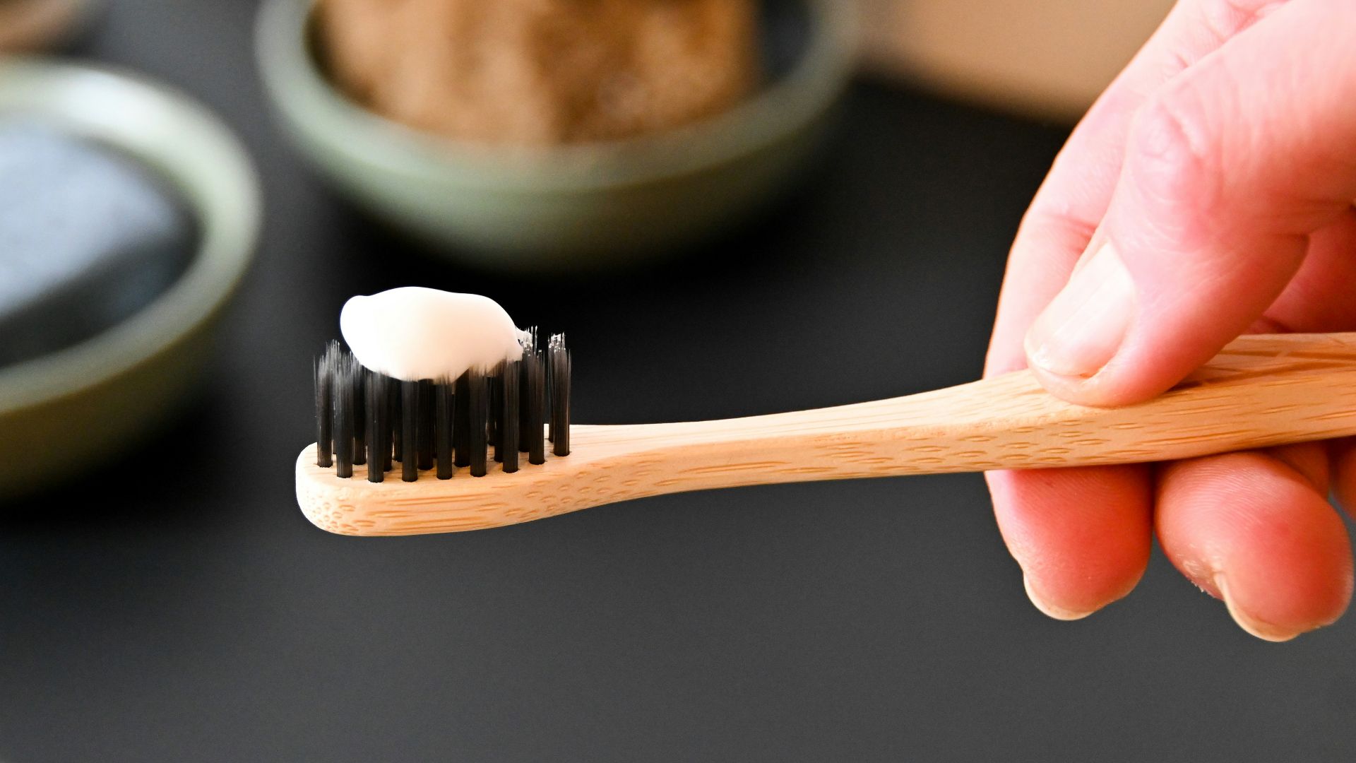 a person holding a toothbrush with a toothpaste on it