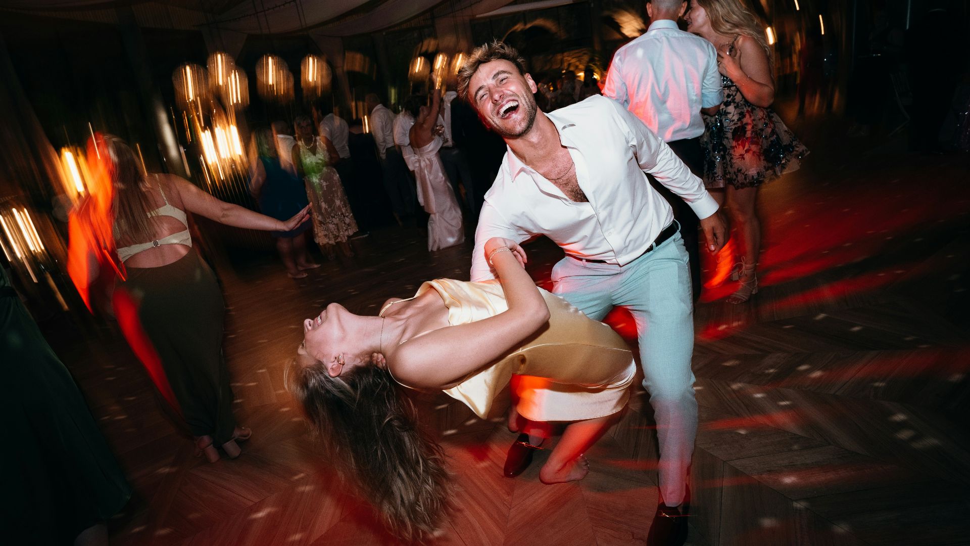 Couple dancing joyfully at a lively outdoor party