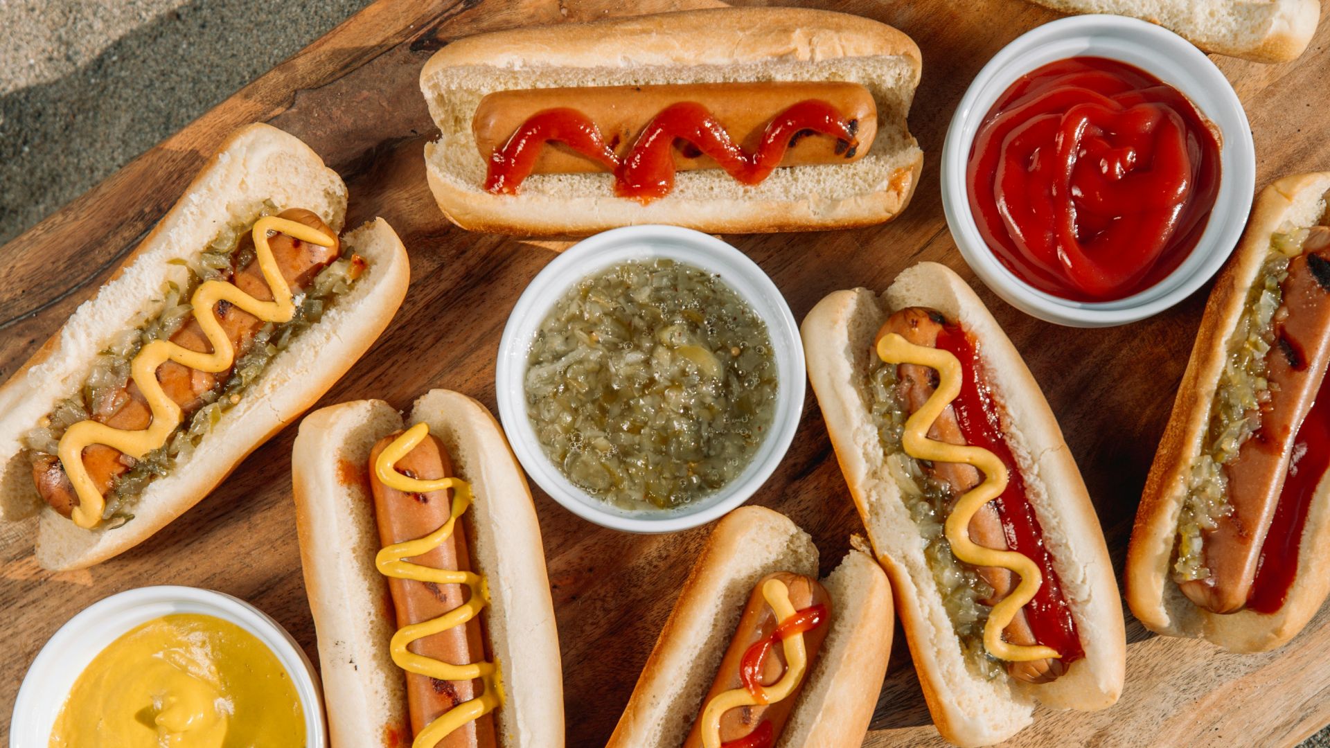 hotdog sandwich with sauce on brown wooden tray