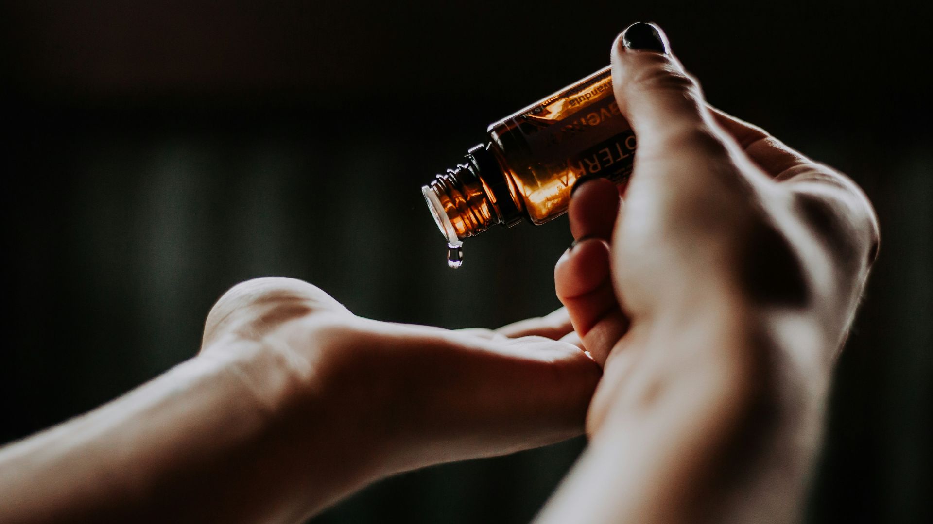 person holding amber glass bottle
